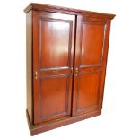 An Edwardian stained pine dressing cupboard or wardrobe, with part fitted interior, set with pegs an