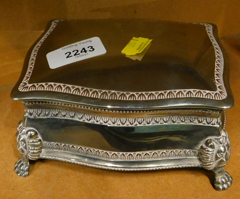 A silver plated lidded casket, on lion head and paw feet, with red velvet lining.