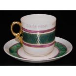 An unusual second period Belleek polychrome tea cup and saucer, decorated with a green ground band b