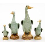 A set of four graduated Chinese celadon glazed models of ducks, each on a rock base with Chinese imp