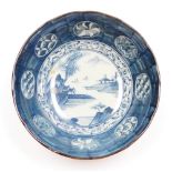 A Japanese blue and white 18thC style bowl, decoration with river and mountain central scene within