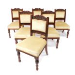 A set of six Victorian mahogany single dining chairs, with carved crest rail, overstuffed beige head