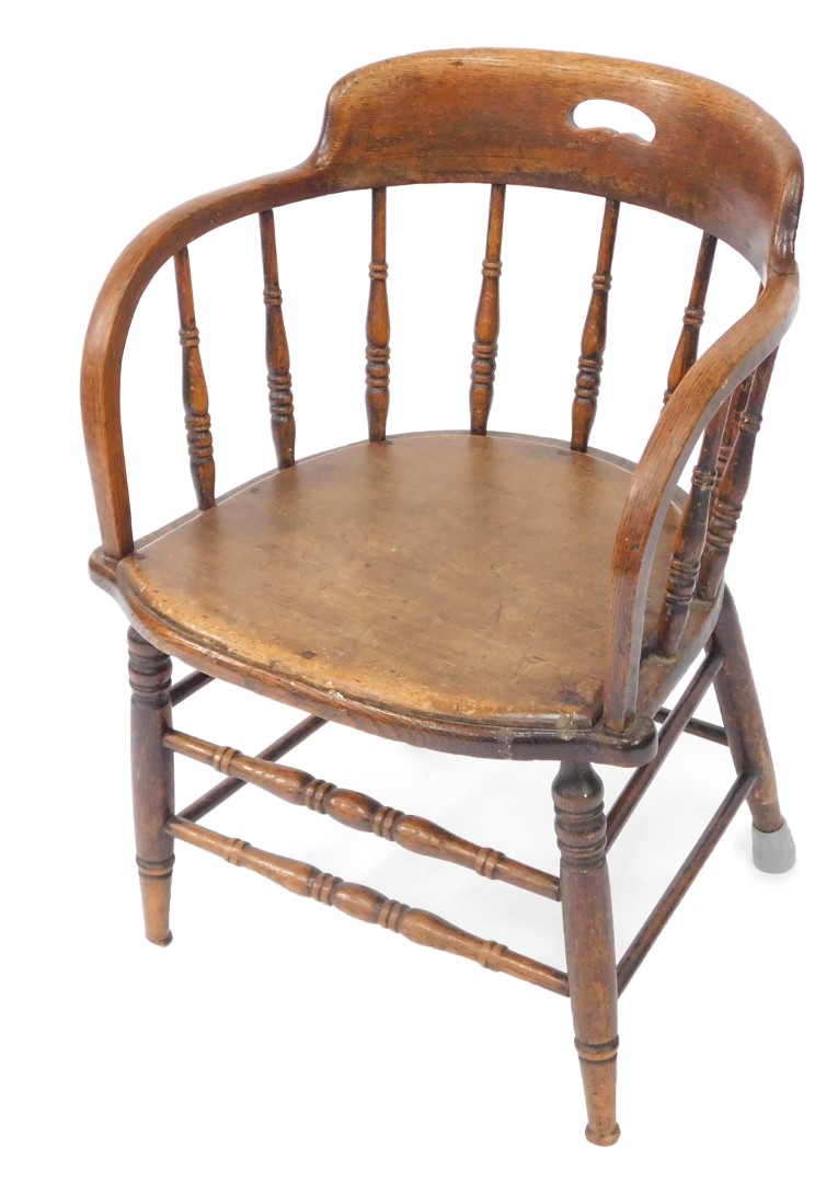 A Victorian oak captain's chair, with a screw down solid seat, raised on turned legs united by turne
