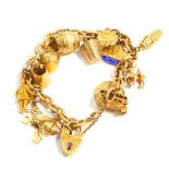 A 9ct gold charm bracelet, with thirteen charms as fitted, on a heart shaped padlock clasp, with saf