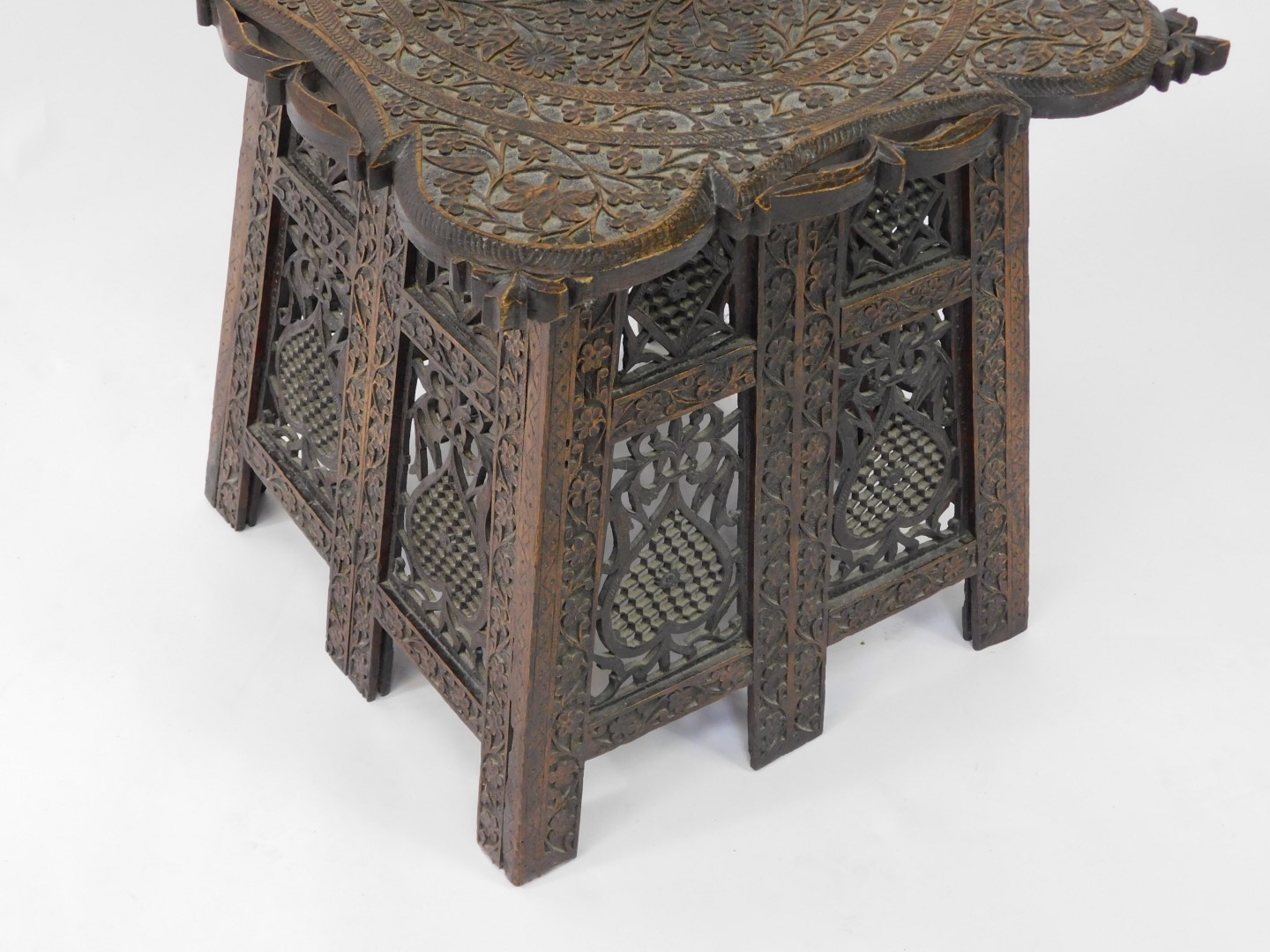 An Indian early 20thC hardwood folding occasional table, the top carved with Arabesques, the sides c - Image 4 of 4
