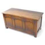 An Old Charm style oak blanket chest, with a triple panelled front, raised on square legs, 53cm high