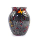 A Poole Pottery flame vase, decorated in silver with a sea weed pattern, against a red ground, raise