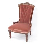 A Victorian mahogany nursing chair, upholstered in red button back velour, with over stuffed seat, r