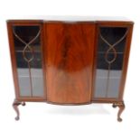 An early 20thC flame mahogany breakfront display cabinet, with a central door opening to reveal two