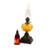 A Victorian late 19thC cast iron oil lamp, with an amber glass reservoir, with glass chimney, 42cm h