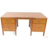 A mid century industrial mahogany twin pedestal desk, with an orange leatherette top, over two drawe