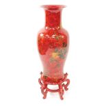 A Chinese red lacquer pottery vase, decorated with birds and blossom, on a circular stand on five sc