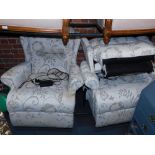 A pair of electric rise and recliner armchairs, upholstered in a floral scroll patterned fabric.