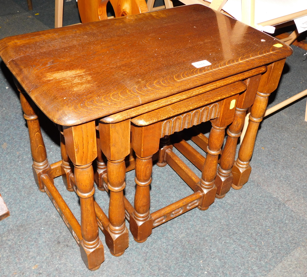 A stained oak nest of tables, 49cm high, 62cm wide, 38cm deep.