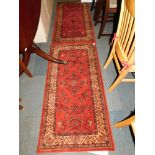 A matching pair of Super Taj machine made wool runners, red ground, 68cm x 137cm.