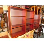 A pair of mahogany effect bookcases, 106cm high, 60cm wide, 28cm deep, together with another small