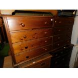 A pine chest of eight long drawers, raised on bun feet, 75m high, 155cm wide, 40cm deep.