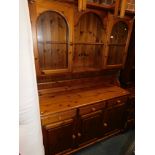 A pine kitchen dresser, with glazed upper cabinets, above a sideboard base, 190cm high, 133cm wide,