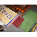 Two wool rugs and a floor mat. (3)