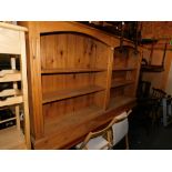 A pine bookcase, enclosing four adjustable shelves, 103cm high, 183cm wide, 27cm deep.