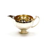 A small George V silver cream jug, with shaped spout on a curved handle, London 1934, maker's stamp