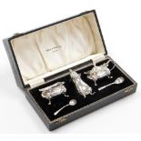 An Elizabeth II Mappin and Webb silver condiment set, two silver mustard spoons, a silver cruet with