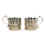 A pair of novelty silver cup cases, each depicting cherubs and flowers, London 1911, 2.5cm high, 1oz
