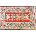 A Middle Eastern cream and orange ground rug, with floral bordering and five central floral medallio