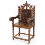 A late 19thC carved oak carver chair, the carved panel back with flowers and sundial decoration, on