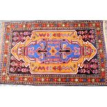 An Iranian multicoloured bordered rug, the star border with elongated central Aztec design medallion