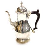 A George V silver coffee pot, with acorn finial top and rococo fluted spout, on an ebonised handle w