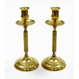 A pair of early 20thC brass candlesticks, each on a tapered column, 23.5cm high.