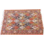 A Middle Eastern orange ground rug, with medallion bordering and tassel ends, machine woven, 224cm x