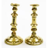 A pair of late 19thC brass candlesticks, each on a circular foot (AF), 21cm high.