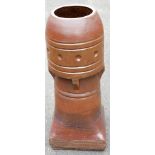 A metal and brown glazed chimney pot turret, the top with beaded design, 80cm high.