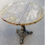 A cast iron based pub table, with three slat wooden top, on a tripod cast iron base, 70cm high, 72cm