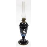 A Victorian opaque glass oil lamp, the oil lamp base on a black finish with painted detailing of blu