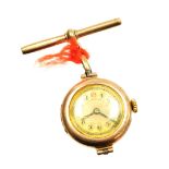A 9ct gold cased wristwatch head converted to a nurses watch, with a 9ct gold t bar clip tied with s