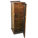 An oak ply collectors cabinet, with an arrangement of thirteen numbered drawers behind single door,