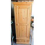 A pine single wardrobe with moulded cornice on pillar sides with applied floral motif with single do