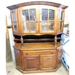 An oak display cabinet, the curved glazed top with four doors above two shelf base with cupboard dra