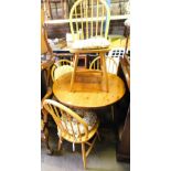 A pine circular kitchen table and set of four stick back chairs, the table 85cm diameter.