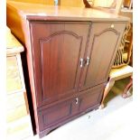 A stained wood television cabinet, with cupboard door and fall flap base, 102cm high, 80cm wide, 46.