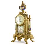 A 20thC continental mantel clock, the brass case decorated with scrolls, swags, etc., with painted
