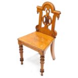 A Victorian oak hall chair, the shaped back with a pierced and carved roundel, on turned legs.