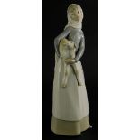 A Lladro porcelain figure of a lady holding a lamb, 27cm high.