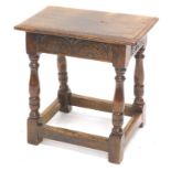 An oak joint stool, the rectangular top with a moulded edge, above a carved frieze on turned