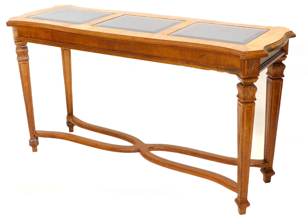 A French hardwood serving table or side table, the shaped top with three smoked glass inserts,