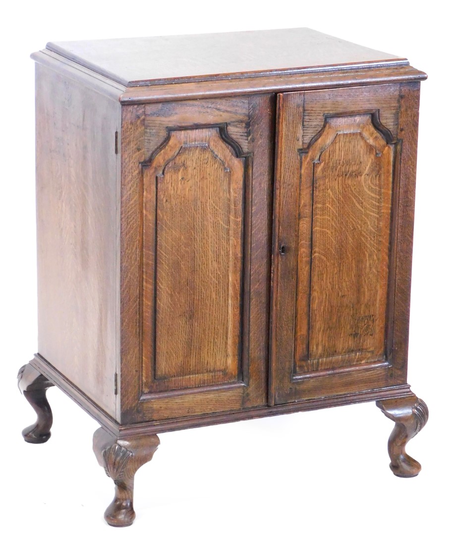 An oak cupboard, the rectangular top with a moulded edge above two panelled doors on short