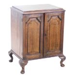 An oak cupboard, the rectangular top with a moulded edge above two panelled doors on short